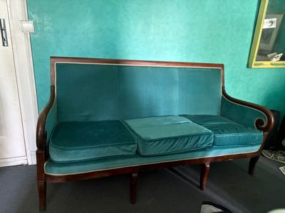 un canapé bleu avec deux coussins dessus, dans une pièce