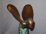 a bronze statue of a woman holding a baseball bat