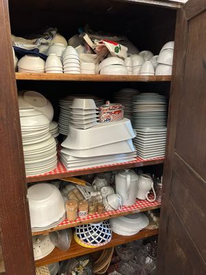 many plates and bowls on the shelves in the kitchen