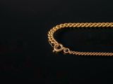 a close up of a gold chain on a black background