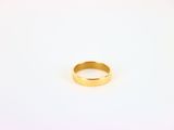 gros plan d'une bague en or sur une surface blanche