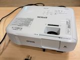 a white projector sitting on top of a wooden table