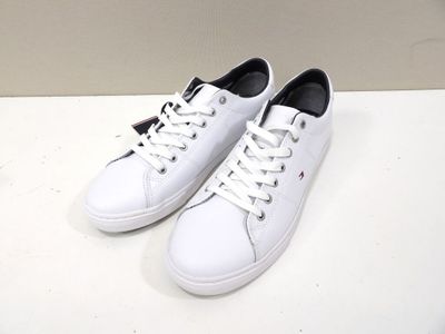 white leather sneakers with black laces on a white surface