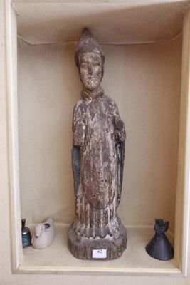 une statue représentant une personne assise sur une petite étagère
