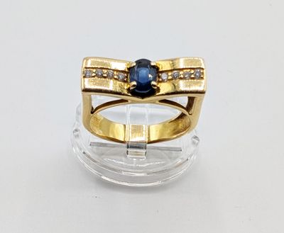 an image of a gold ring with a sapphire stone and diamonds