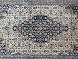 a blue and beige rug with a medallion design on it