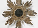 un motif « sunburst » doré avec un miroir noir au centre