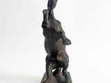statue of a woman riding a horse on a wooden base