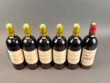 six bottles of wine lined up in a row on a table