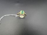 Gros plan sur une bague ornée d'une pierre verte