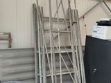 a lot of ladders that are stacked up in a garage