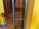 une photo d'une cuisine avec une étagère métallique au milieu de la pièce