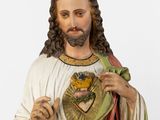 statue of jesus holding a heart and a cross in his hands