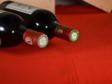 three bottles of wine sitting on a red table