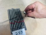 a person holding a bunch of drill bits in their hand