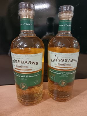deux bouteilles de whisky posées l'une à côté de l'autre sur une table