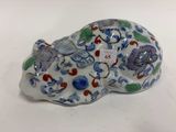 une figurine représentant un chat, ornée de fleurs et d'oiseaux