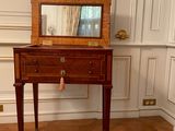 a small wooden table with a mirror on top of it