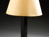 une lampe de table noire surmontée d'un abat-jour beige