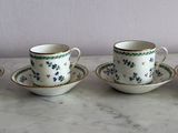 quatre tasses et soucoupes sont alignées sur une table en marbre