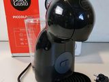 a black coffee machine sitting on a table next to a box