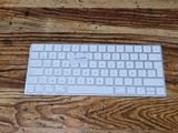 a white keyboard sitting on a wooden table next to a mouse
