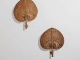 une paire de crochets muraux en rotin sur un mur blanc