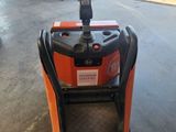 un chariot élévateur orange et noir garé dans un garage