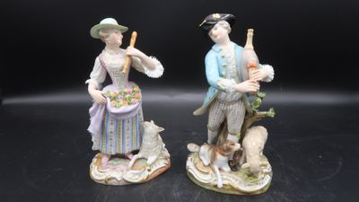 two figurines of a man and a woman with a dog