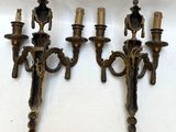 three antique brass wall sconces on a white background