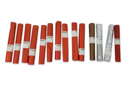 Plusieurs rouleaux de papier rouge et blanc sont alignés sur une surface blanche
