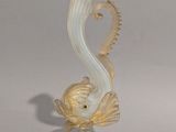 une figurine en verre représentant un poisson, posée sur un socle