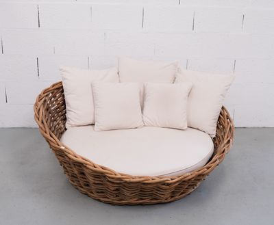 une photo d'une chaise en osier sur laquelle sont posés quatre coussins