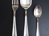 three spoons and a fork on a black table