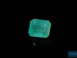 a green emerald stone on a black surface