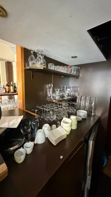 a bar with a lot of wine glasses and plates on it