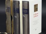 trois livres sont empilés sur une table