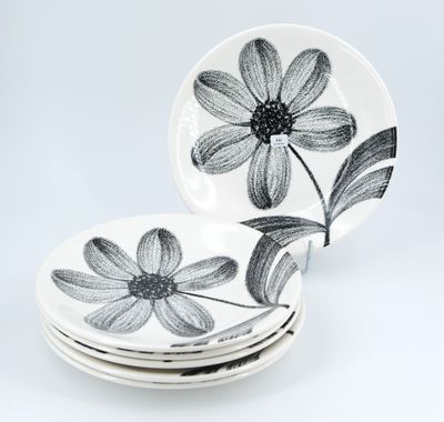 a stack of plates with black and white flowers on them