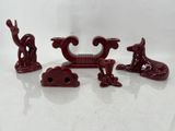 trois figurines rouges posées sur une table blanche