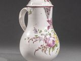 un vase blanc orné d'un motif floral rose et jaune