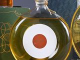 two bottles of olive oil and a bottle of honey on a table