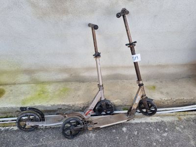 deux scooters posés par terre près d'un mur