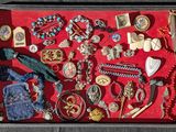a shadow box filled with assorted jewelry on a red surface