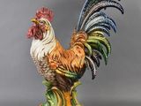 une statue représentant un coq posée sur un socle vert