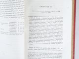 an open book with a red cover on a white table