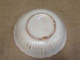a white bowl sitting on a table with a brown cloth