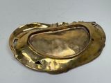 an image of a gold plate with a leaf design on it