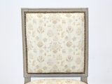 a white chair with a floral upholstered back