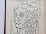 drawing of a man ' s face in a book with a pen