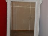 a mirror sitting on the floor in front of a red wall
